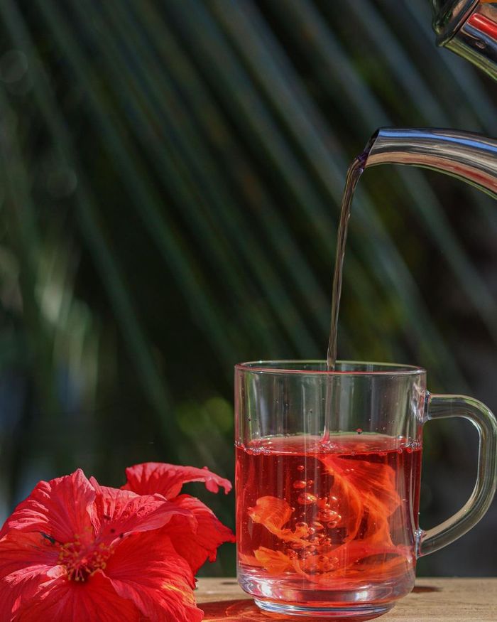 A ruby-red hibiscus and berry cooler served over ice with lime
