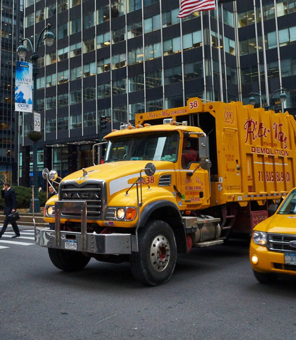 Yellow garbage truck on city street