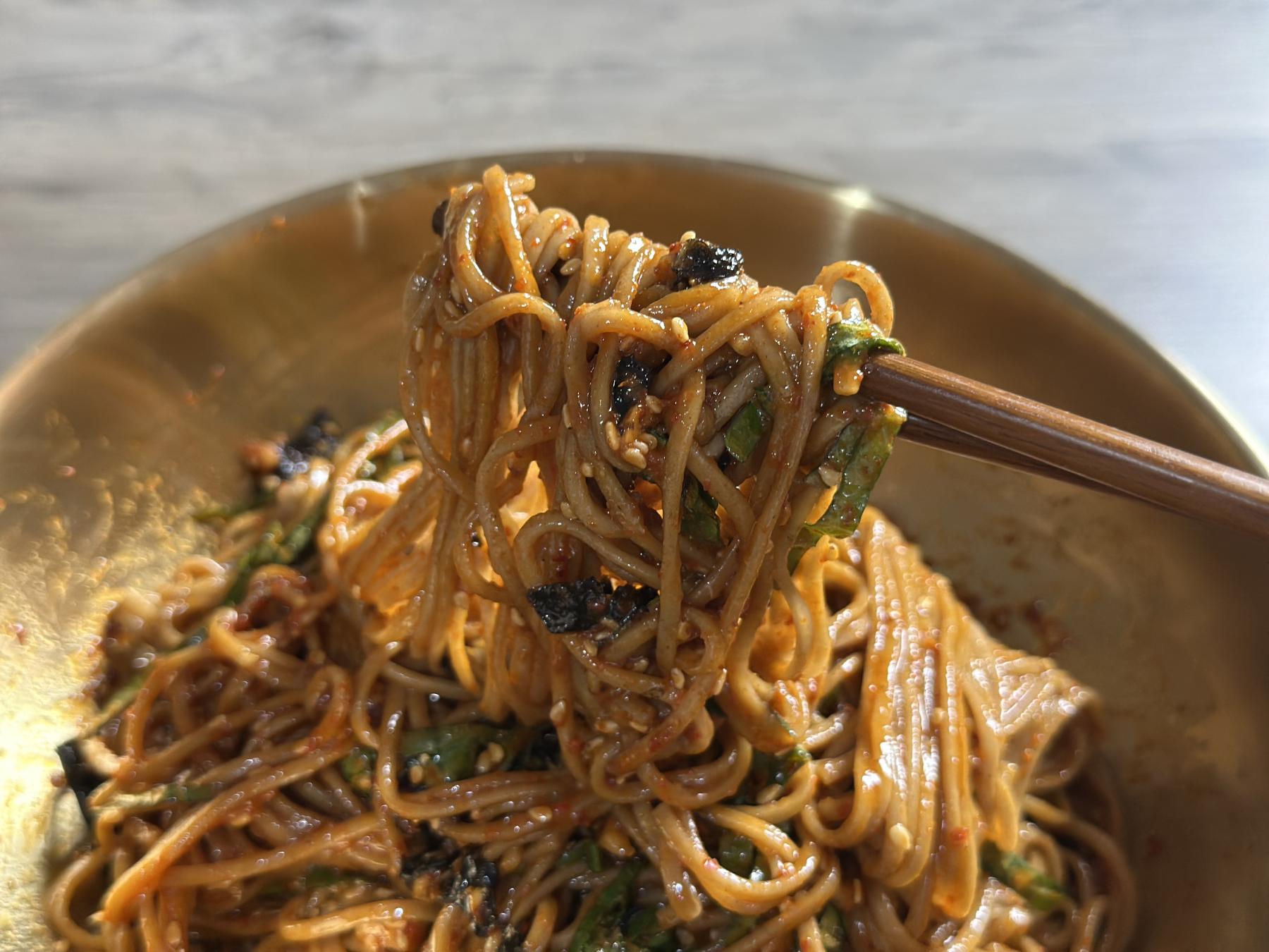 holding makguksu with chopsticks