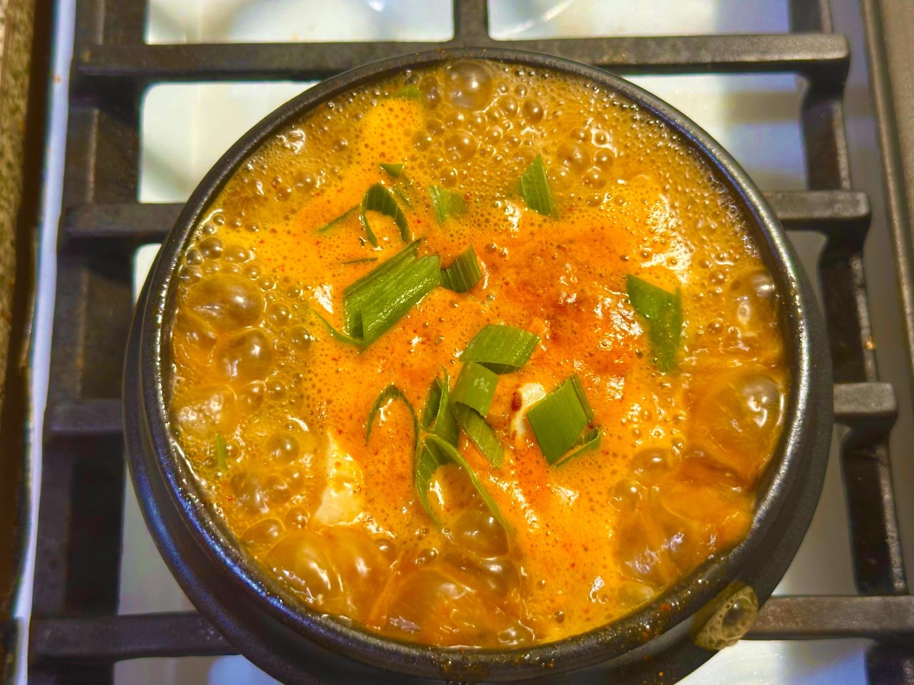 chopped green onion added to the boiling pot