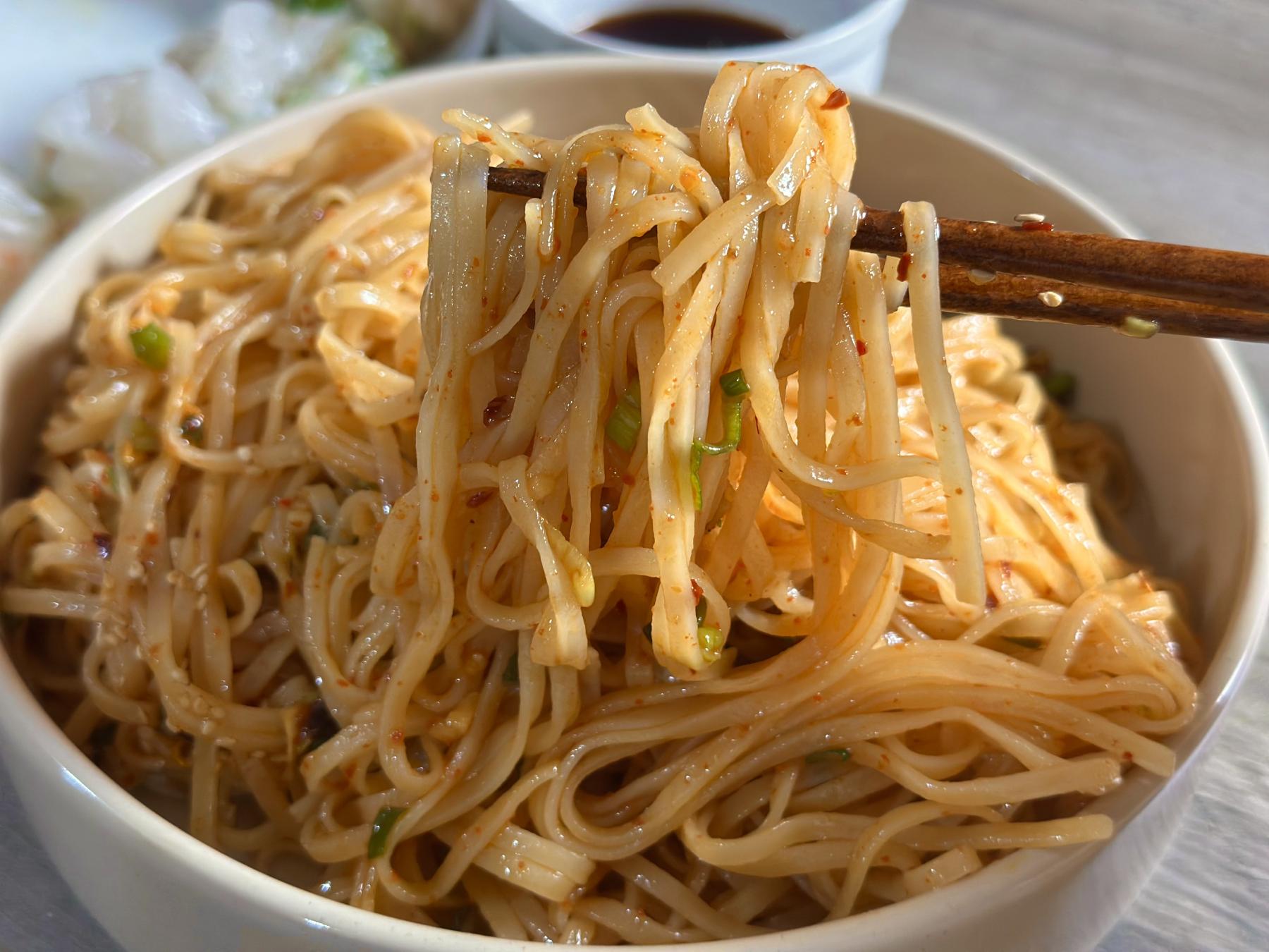 holding chili noodles with chopsticks