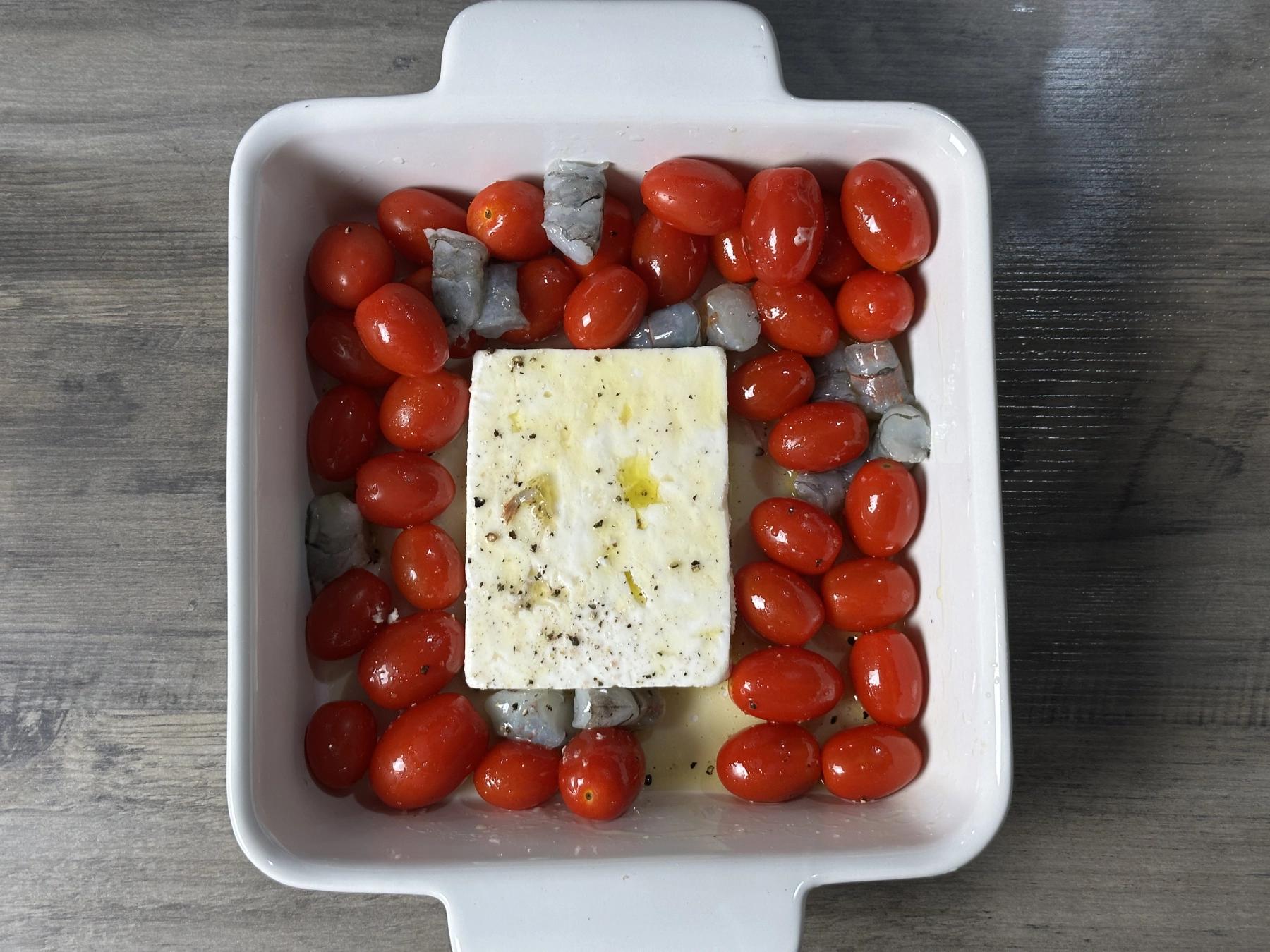 feta cheese, cherry tomatoes, shrimps in a baking pot