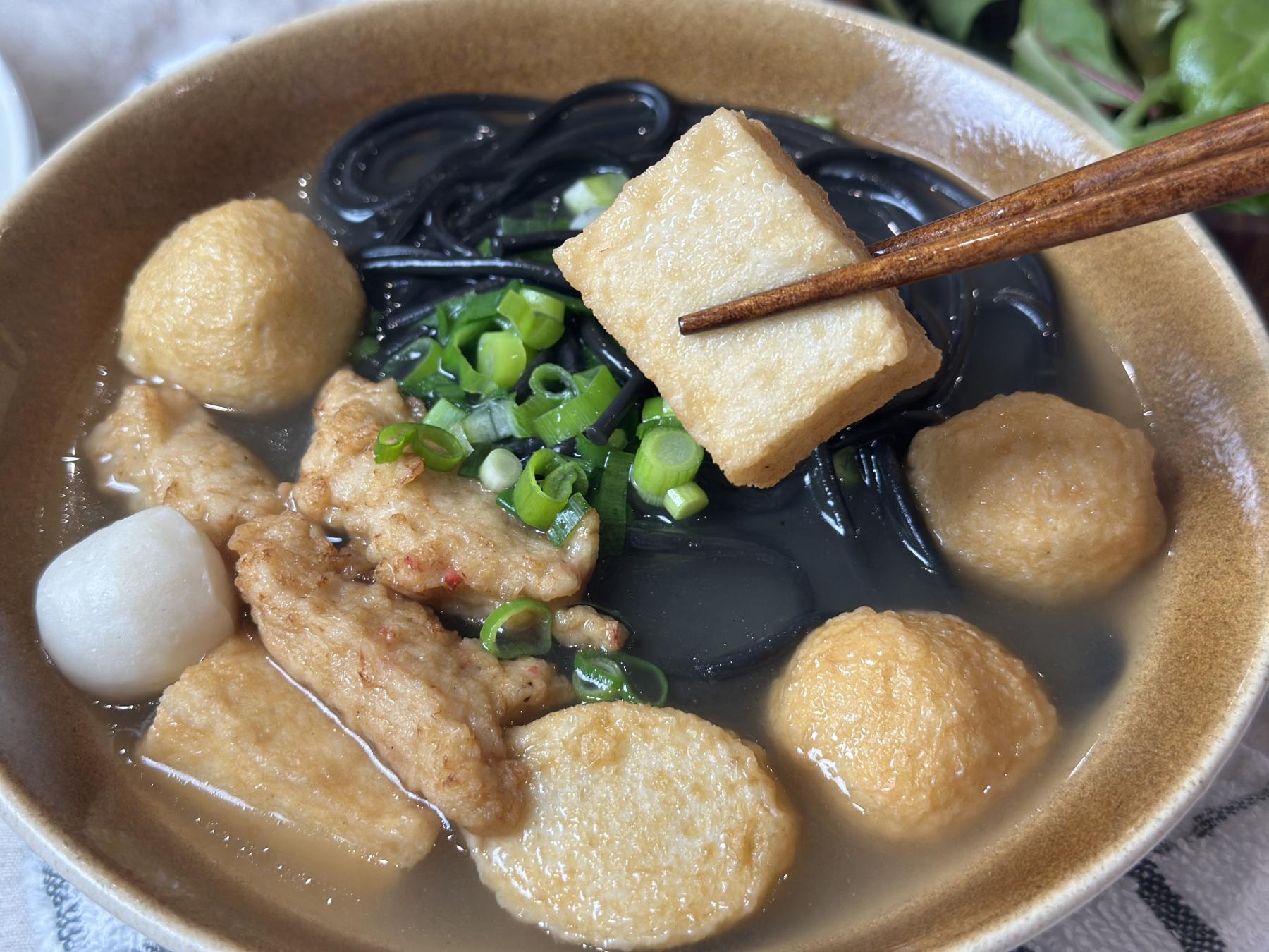 holding fishcake with chopsticks