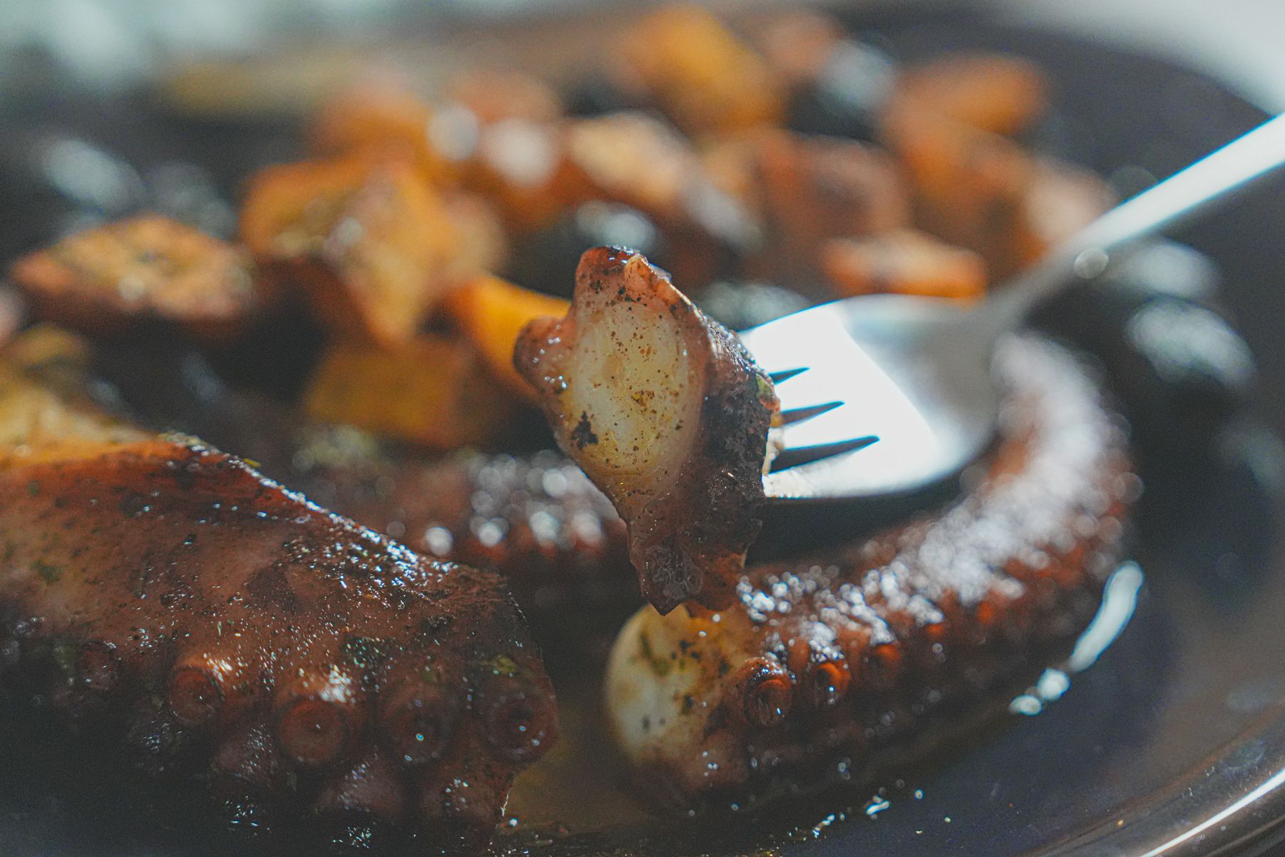 holding sliced octopus with forks