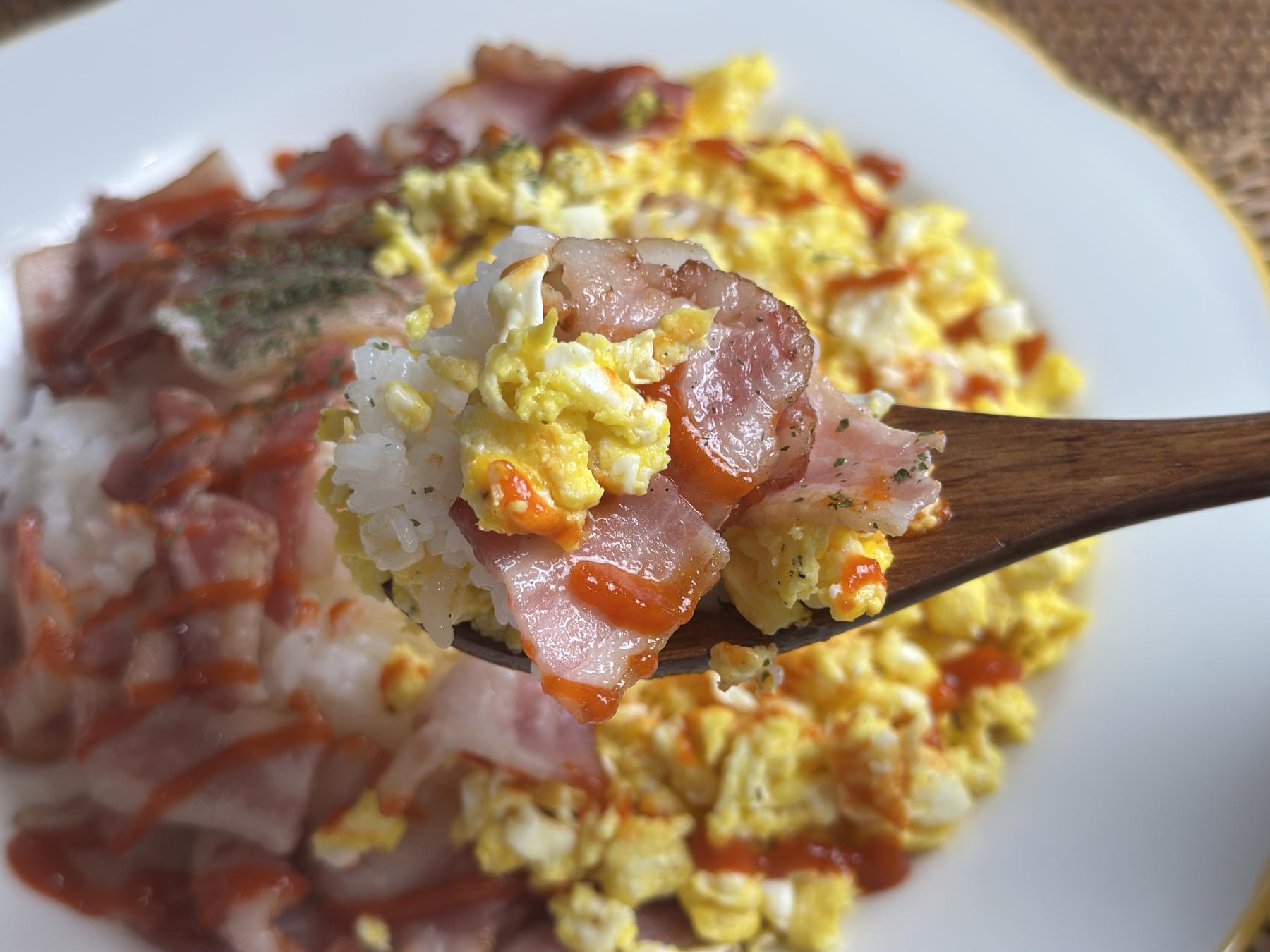 bacon egg over rice on the spoon