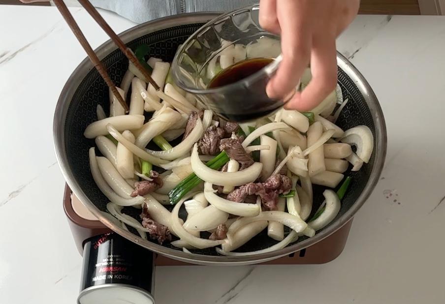 adding soy sauce into the pan