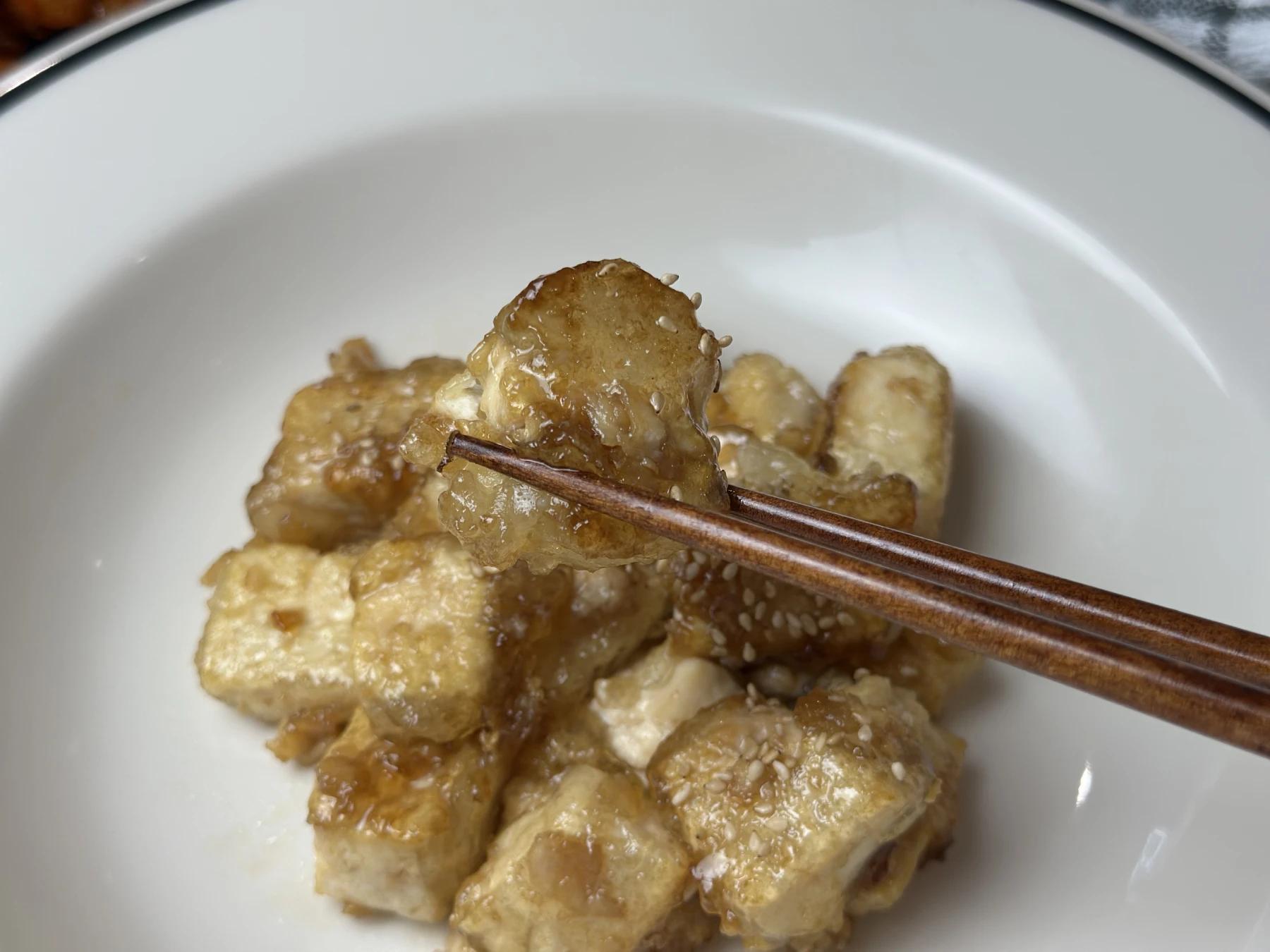 holding fried tofu with chopsticks