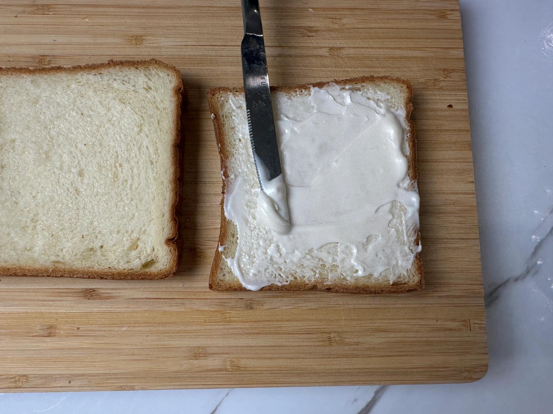 spread mayonaisse on the bread surface