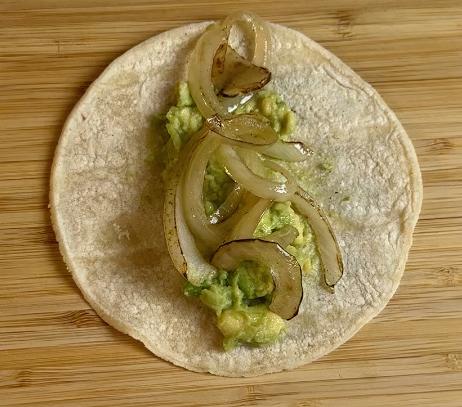 stir-fried onions on the tortilla