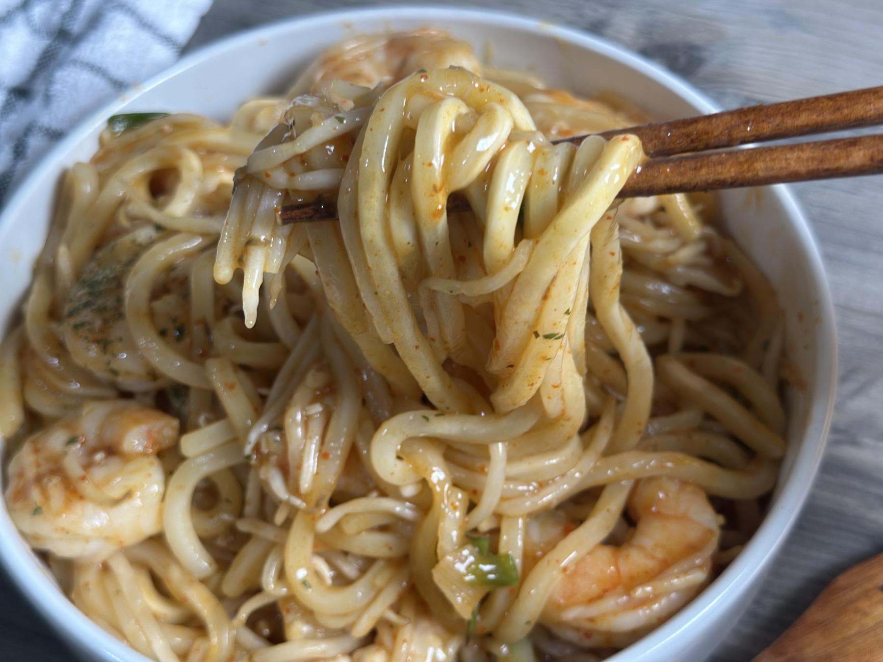 holding udon noodles with chopsticks