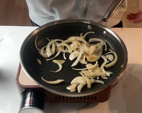 sliced onions on the pan with oil