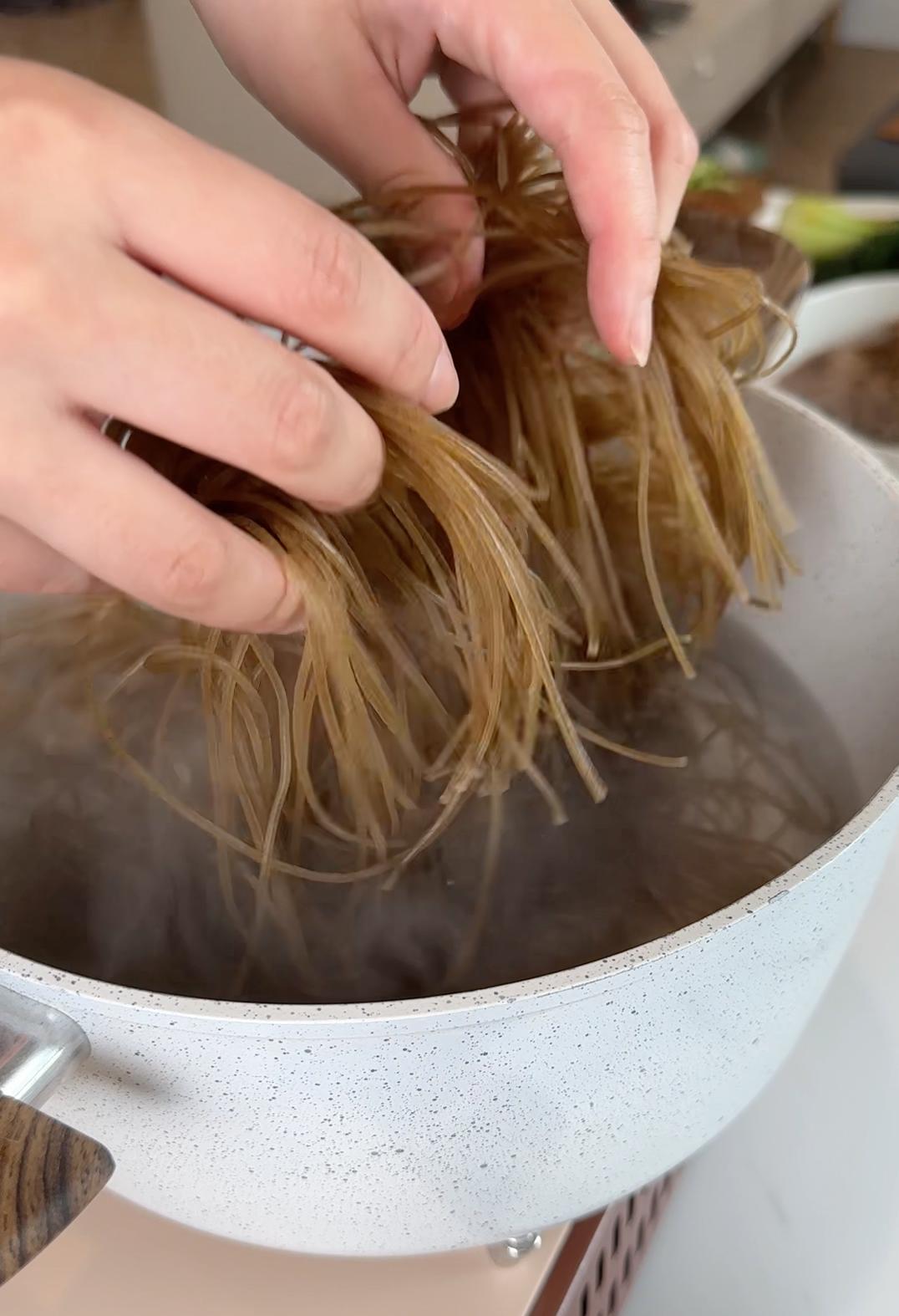 adding noodles to boiling water