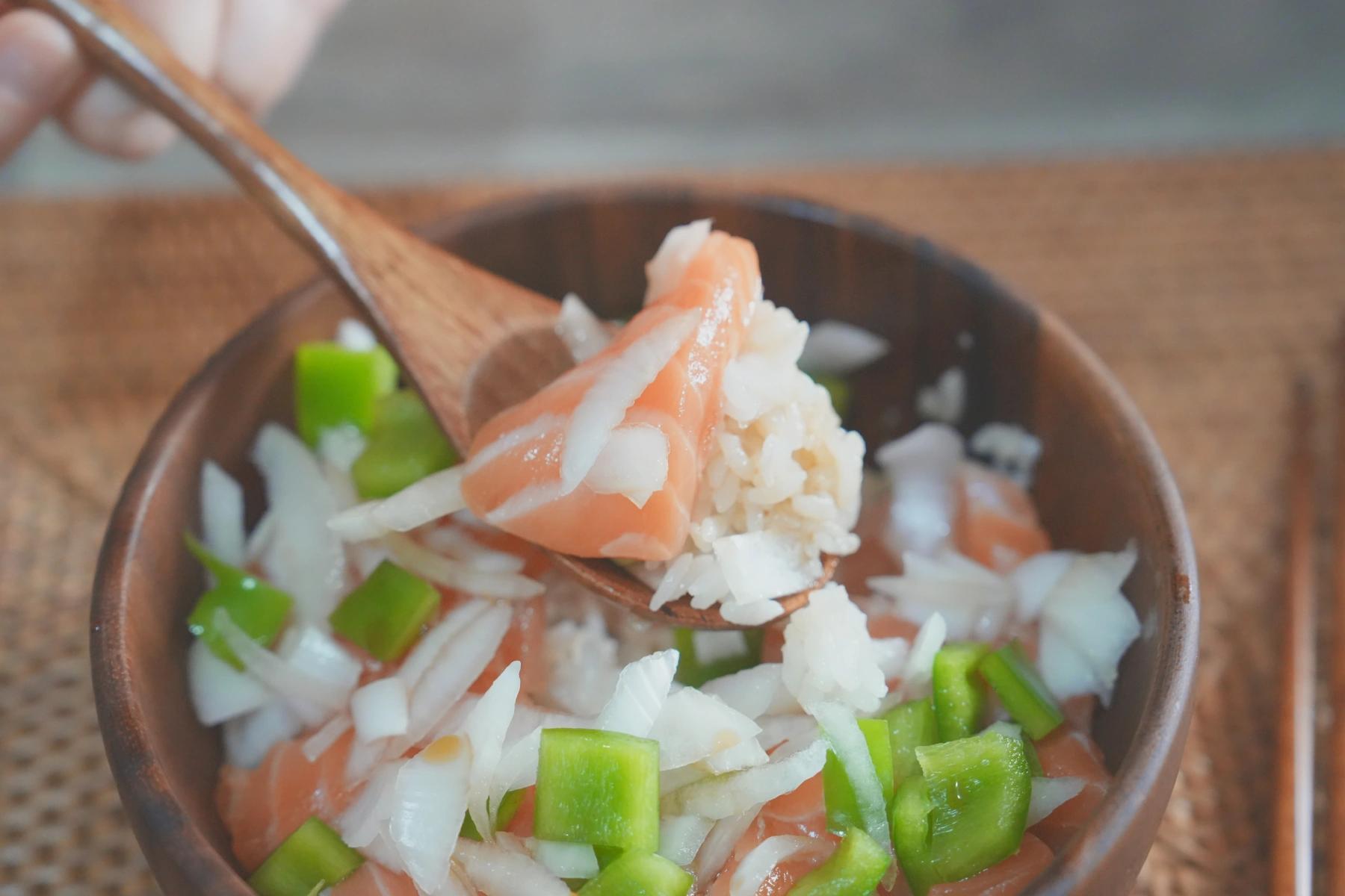 holding rice, salmon and onion