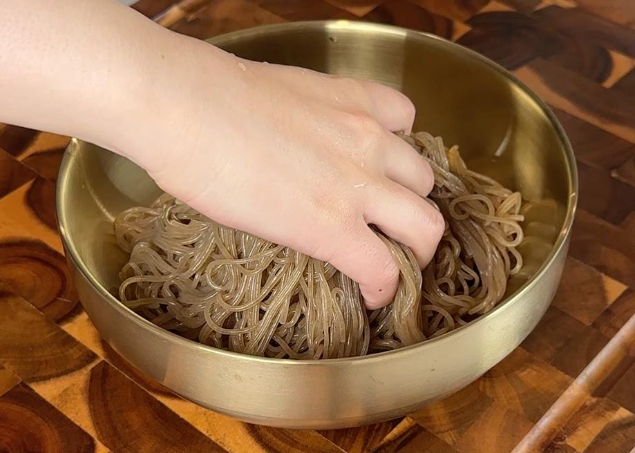 assembling cold noodles in a bowl