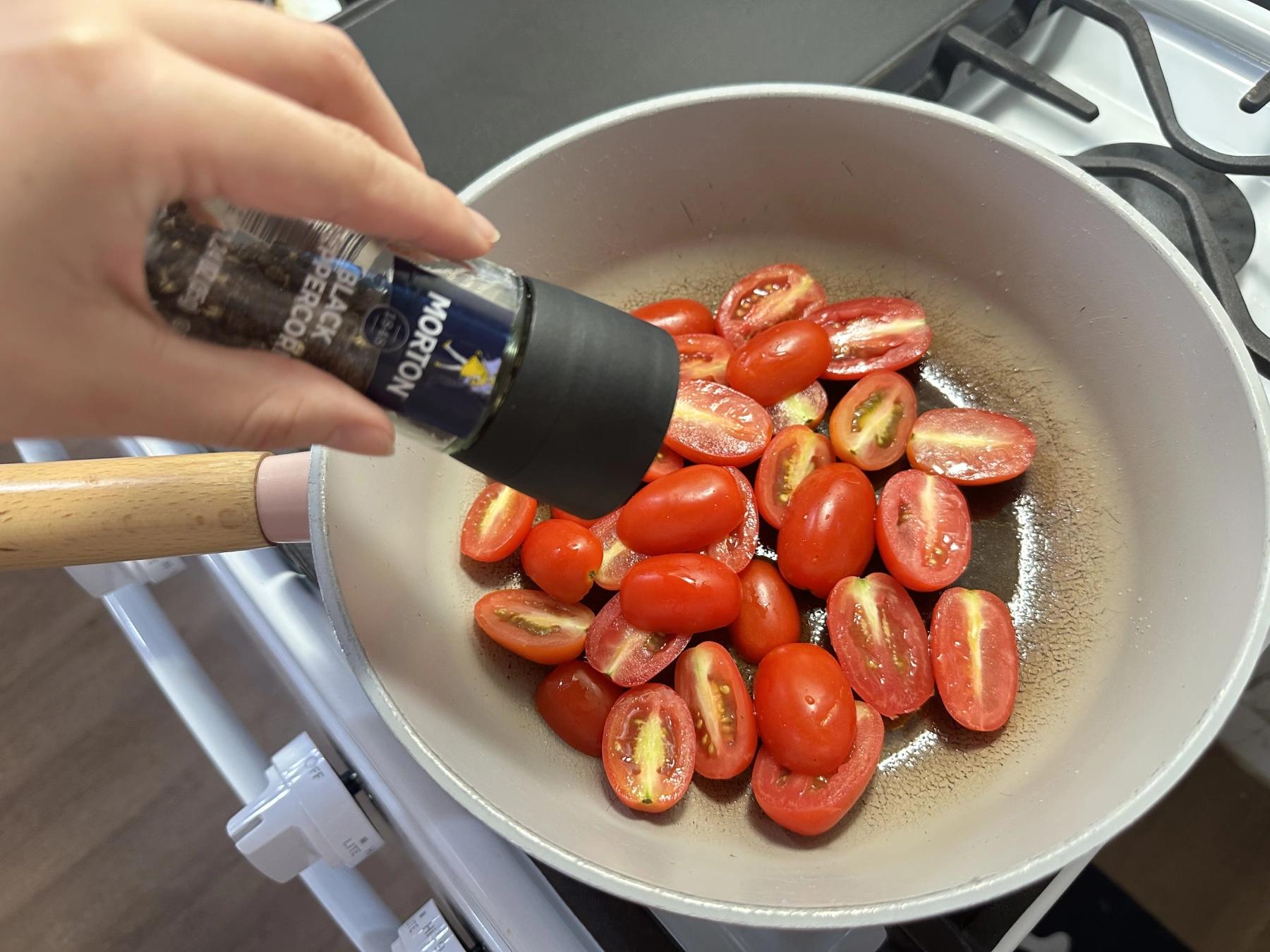 grinding black pepper into pasta