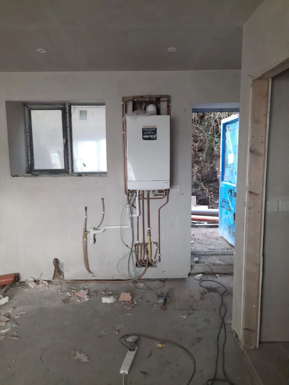 New boiler fitted on the wall of a new-build house