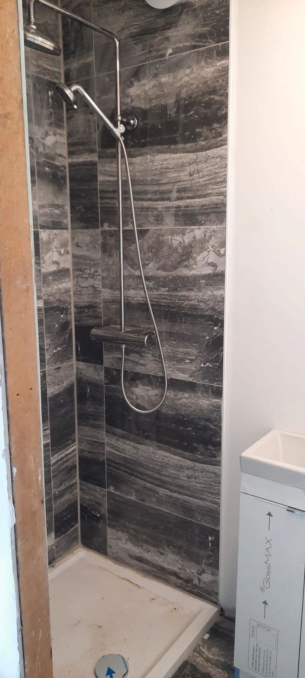 Dark-tiled shower with rainfall head, handset and thermostatic valve