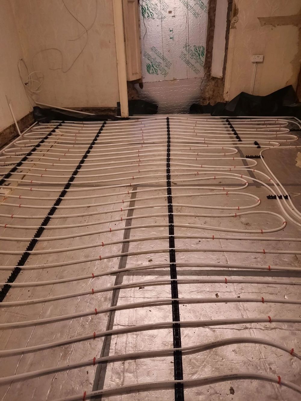 Underfloor heating pipes in a room with a doorway