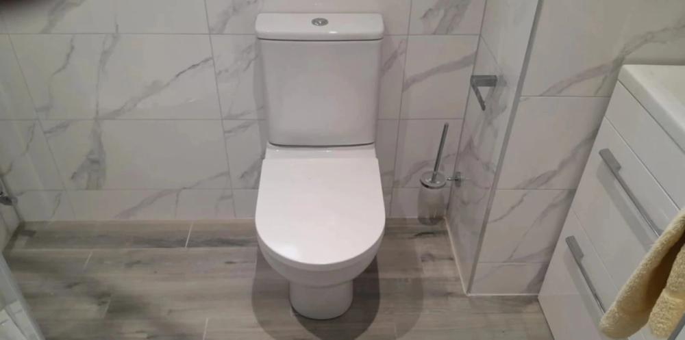 New toilet installed in a marble-tiled bathroom