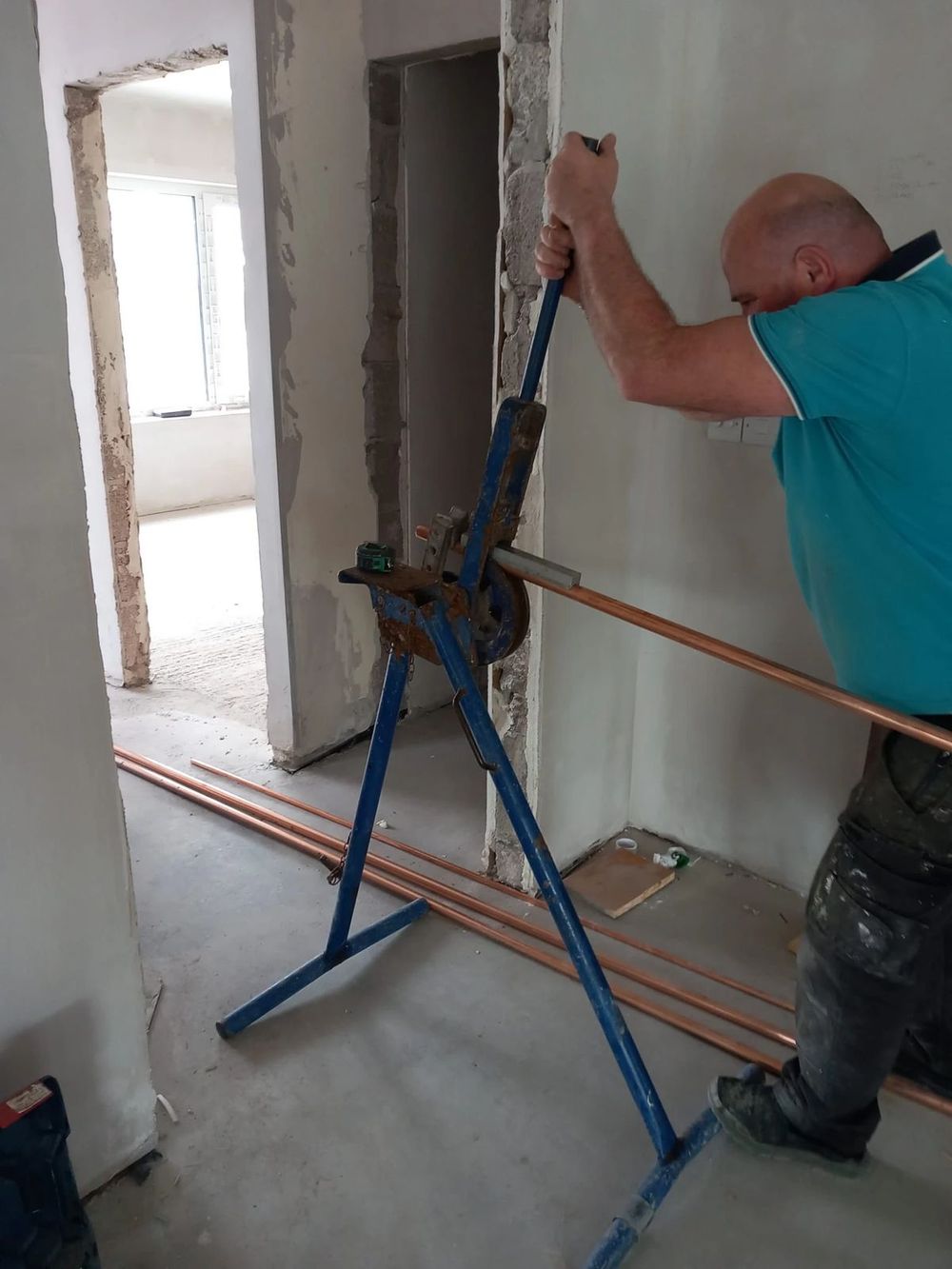 Adam Wagner bending copper pipe on site