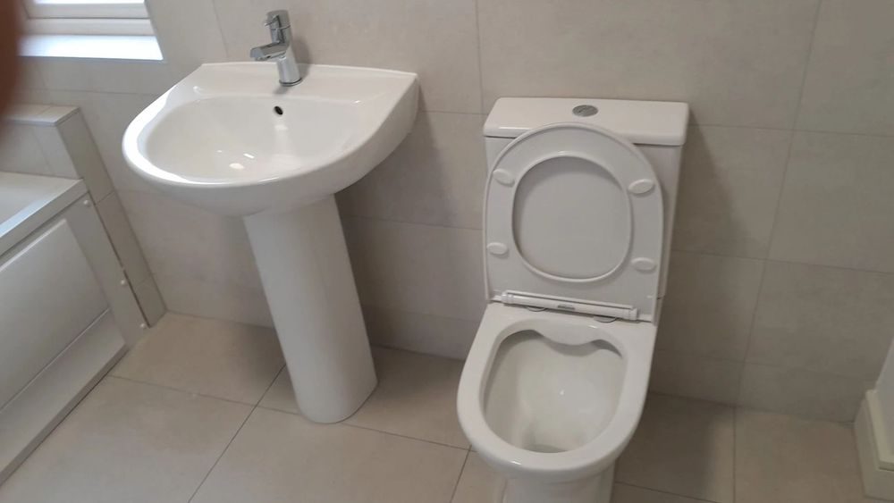 Newly fitted sink and toilet in a bathroom