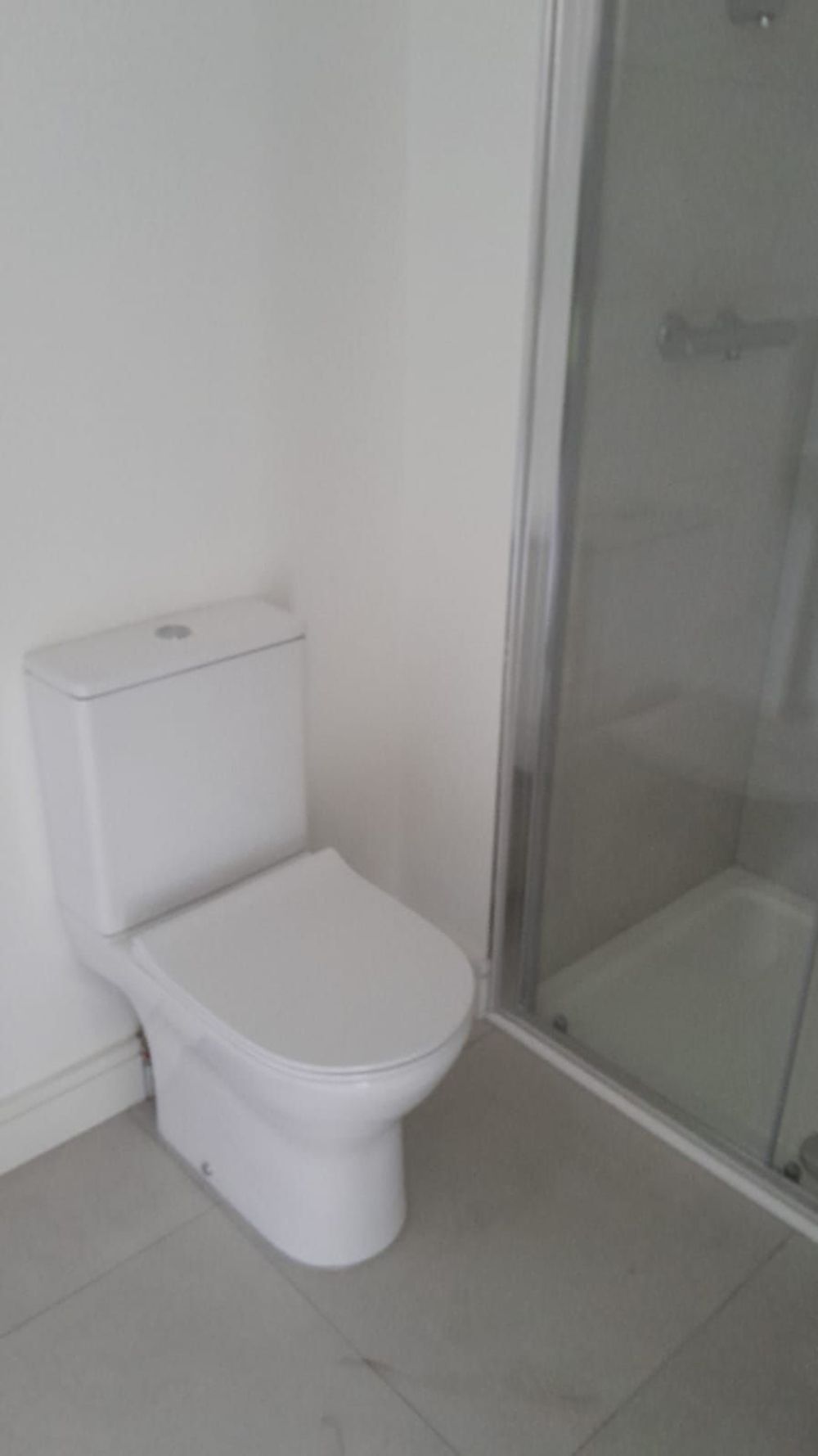 Toilet installed beside a shower in a refitted bathroom
