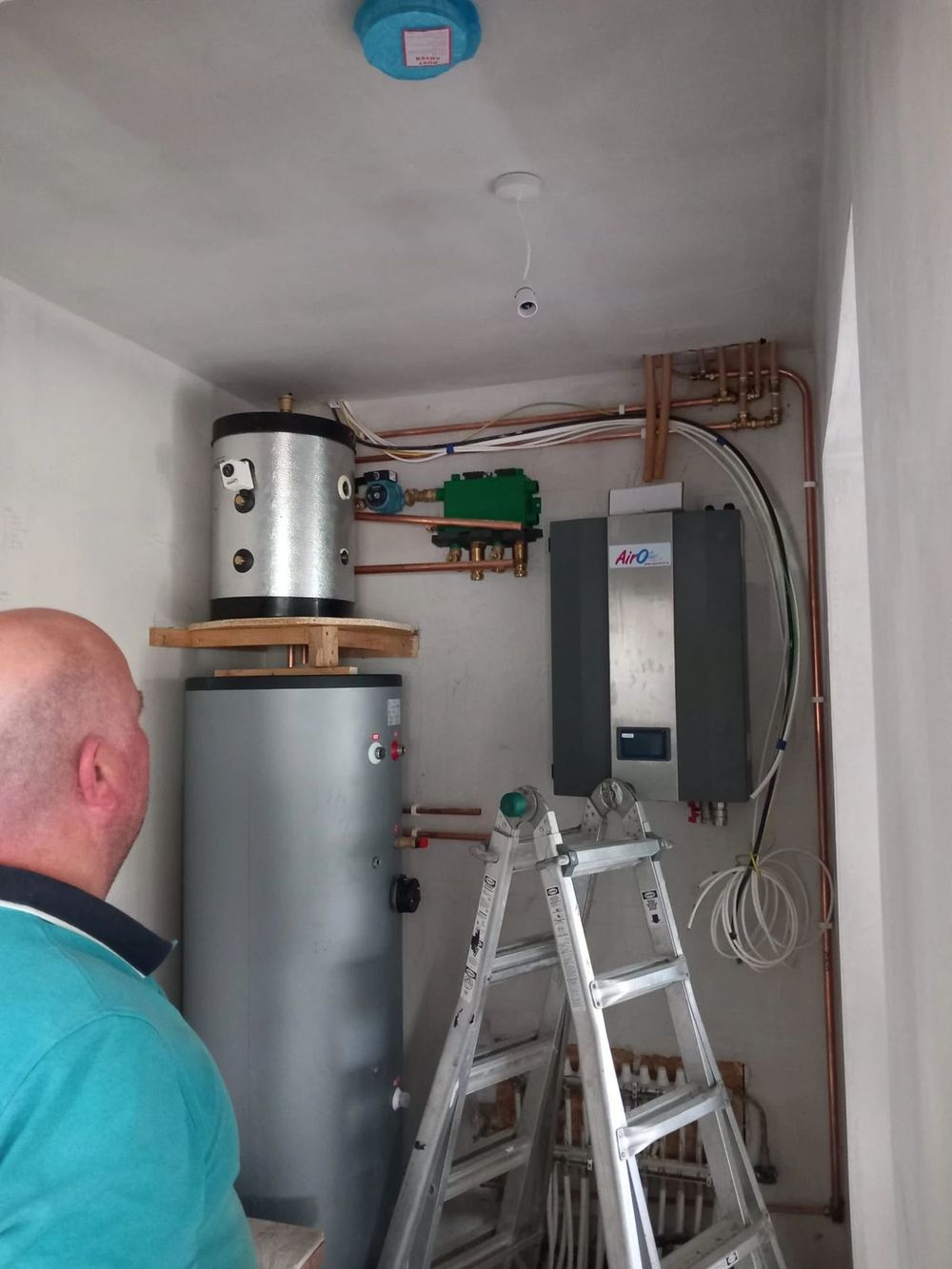 Heat pump plant room with cylinder and manifold being installed