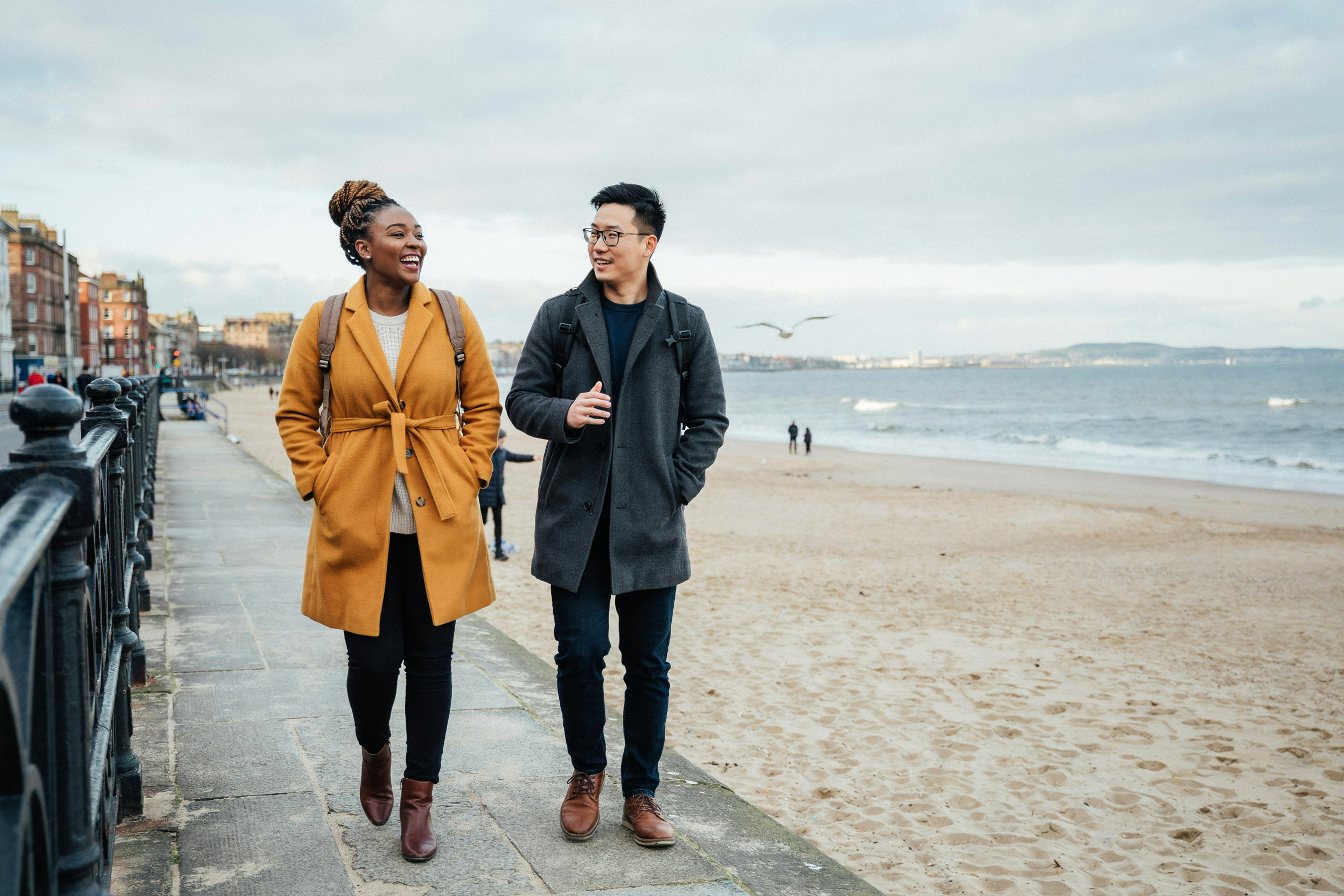 Two students walking along Portobello promenade in Edinburgh in winter