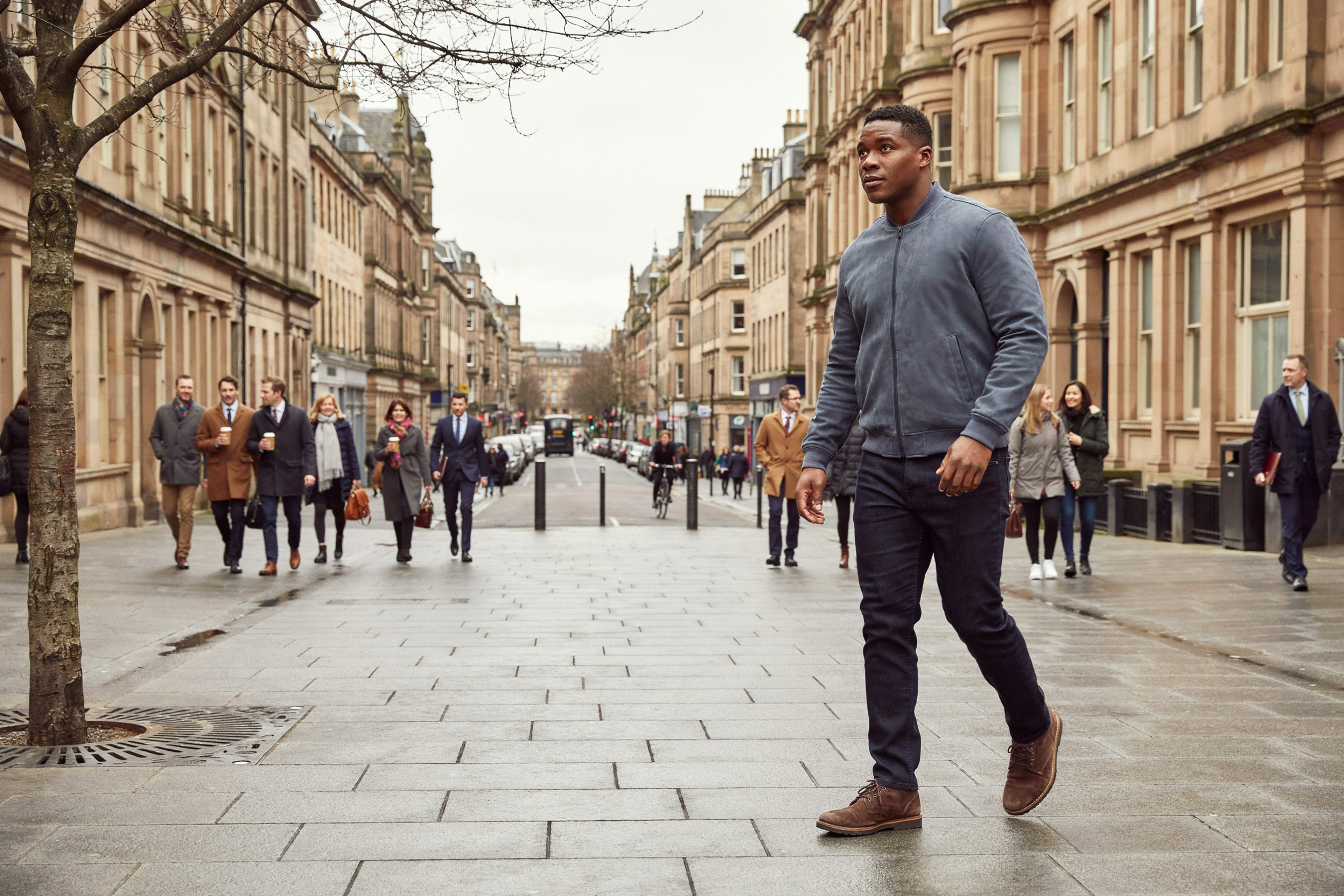 Office worker walking along a city-centre street in Edinburgh at lunchtime in autumn