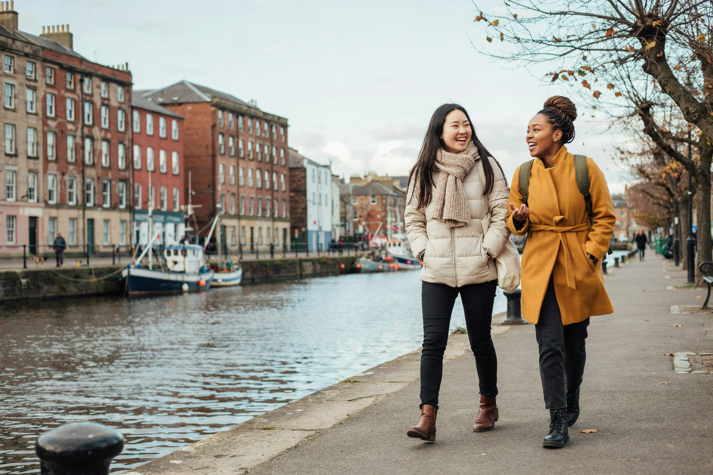Two students walking along The Shore in Leith, Edinburgh, in winter