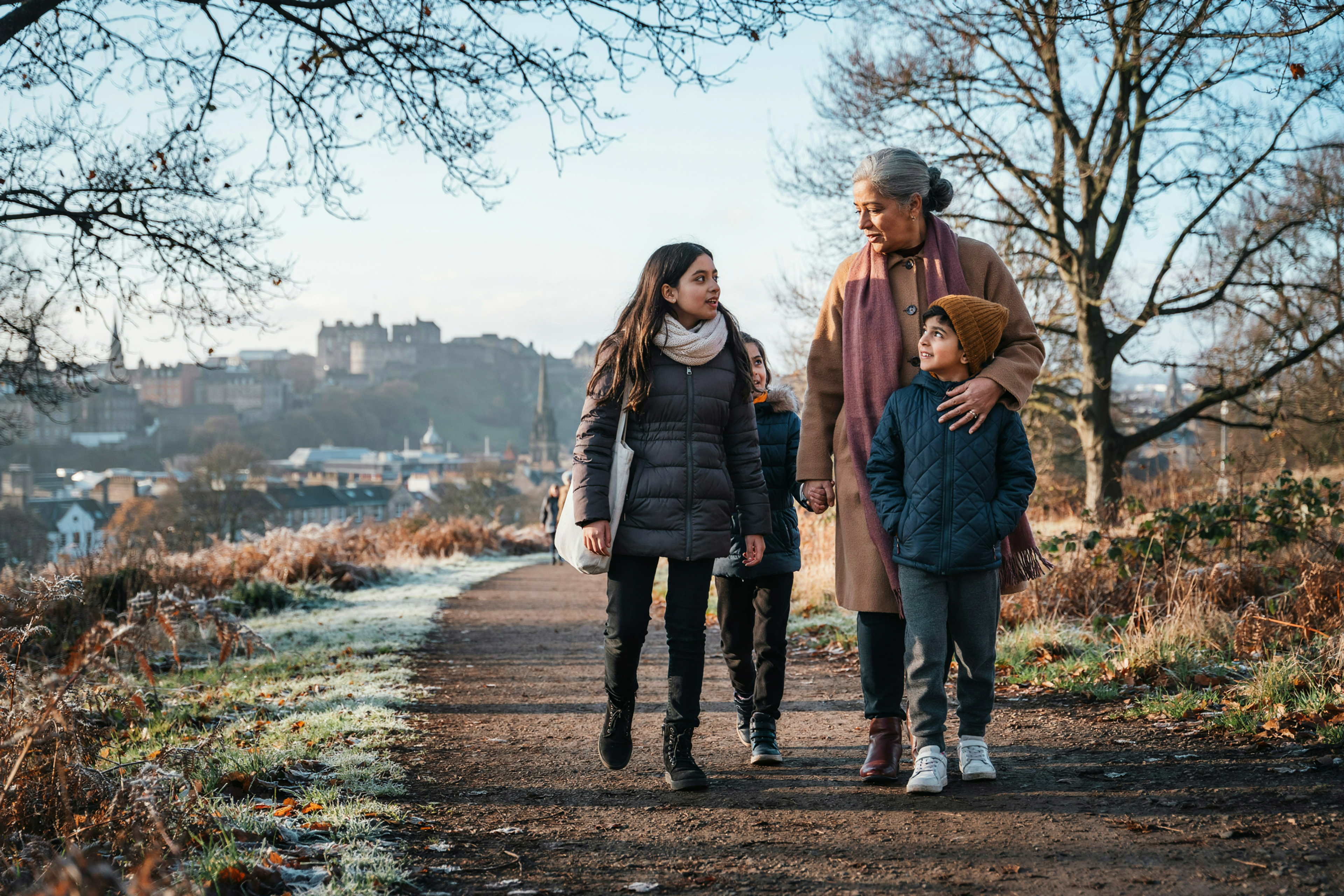 Grandmother walking with her grandchildren on Blackford Hill in Edinburgh in winter