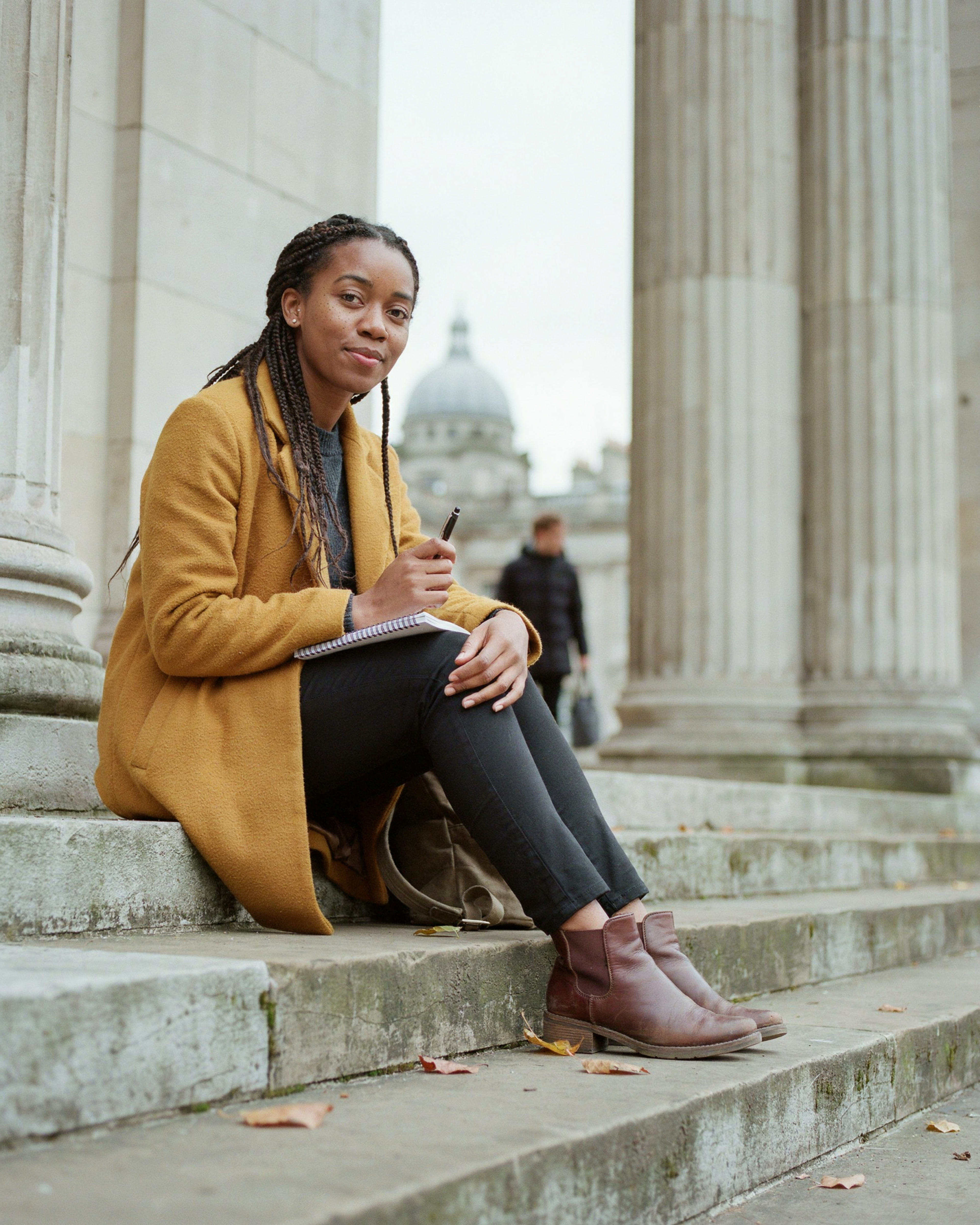 Student sitting outside Old College at the University of Edinburgh