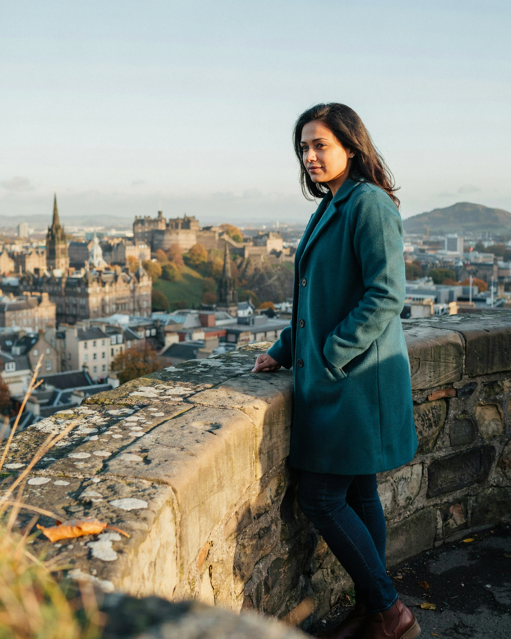 Woman looking out over Edinburgh from Calton Hill on an autumn morning