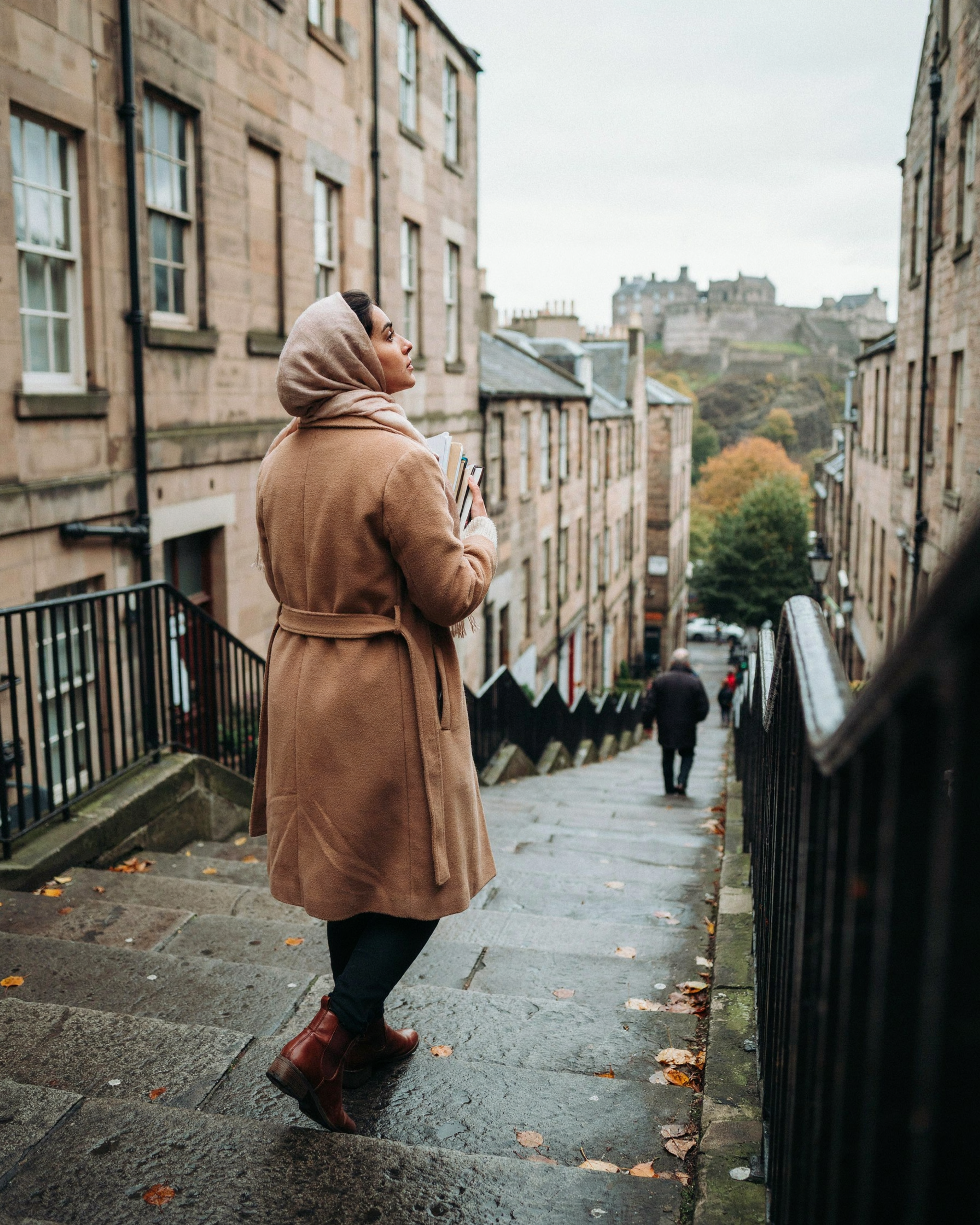 Student on the Vennel steps in Edinburgh's Old Town with the castle behind