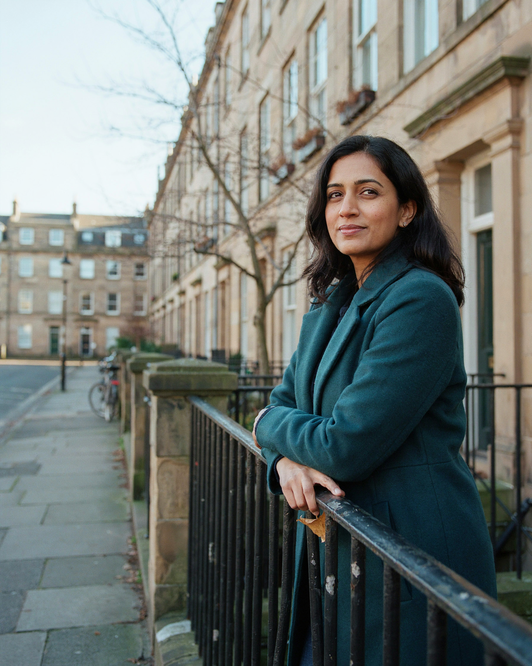 Woman taking a breath of fresh air outside her tenement in Marchmont, Edinburgh, on a cold morning