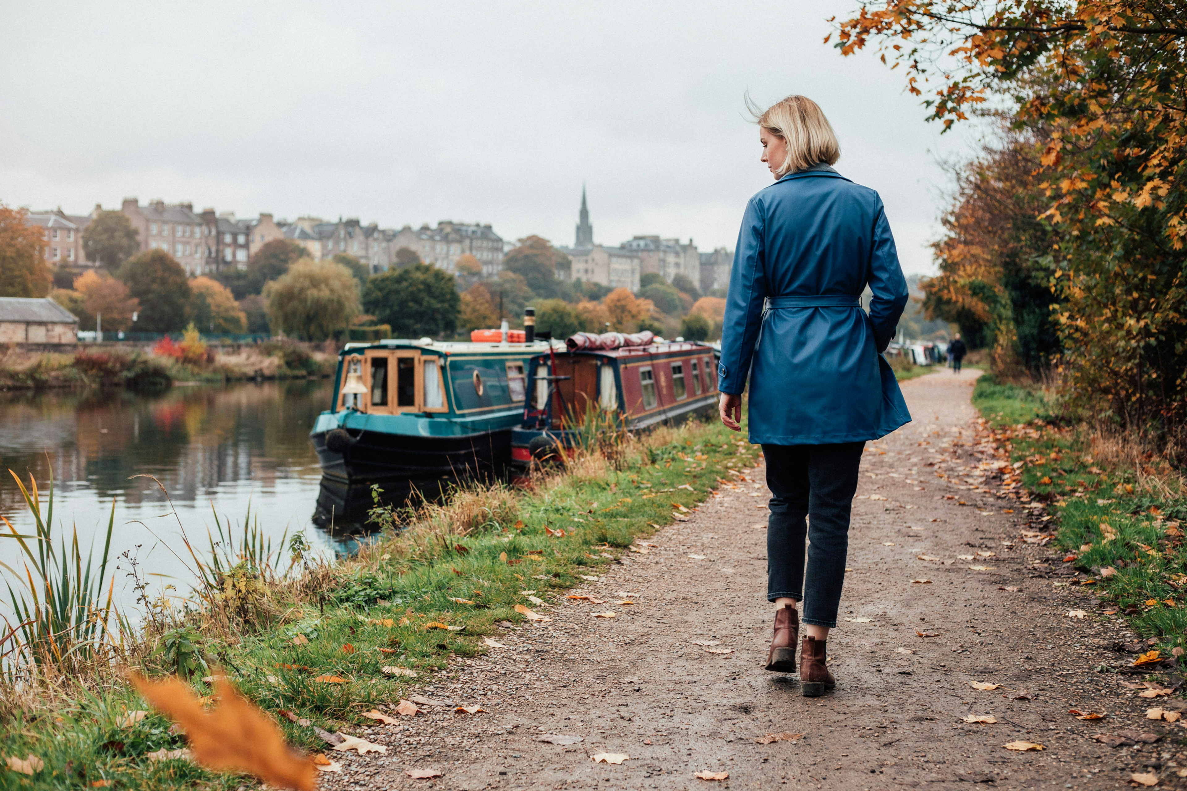 Student walking along the Union Canal towpath in Edinburgh in autumn