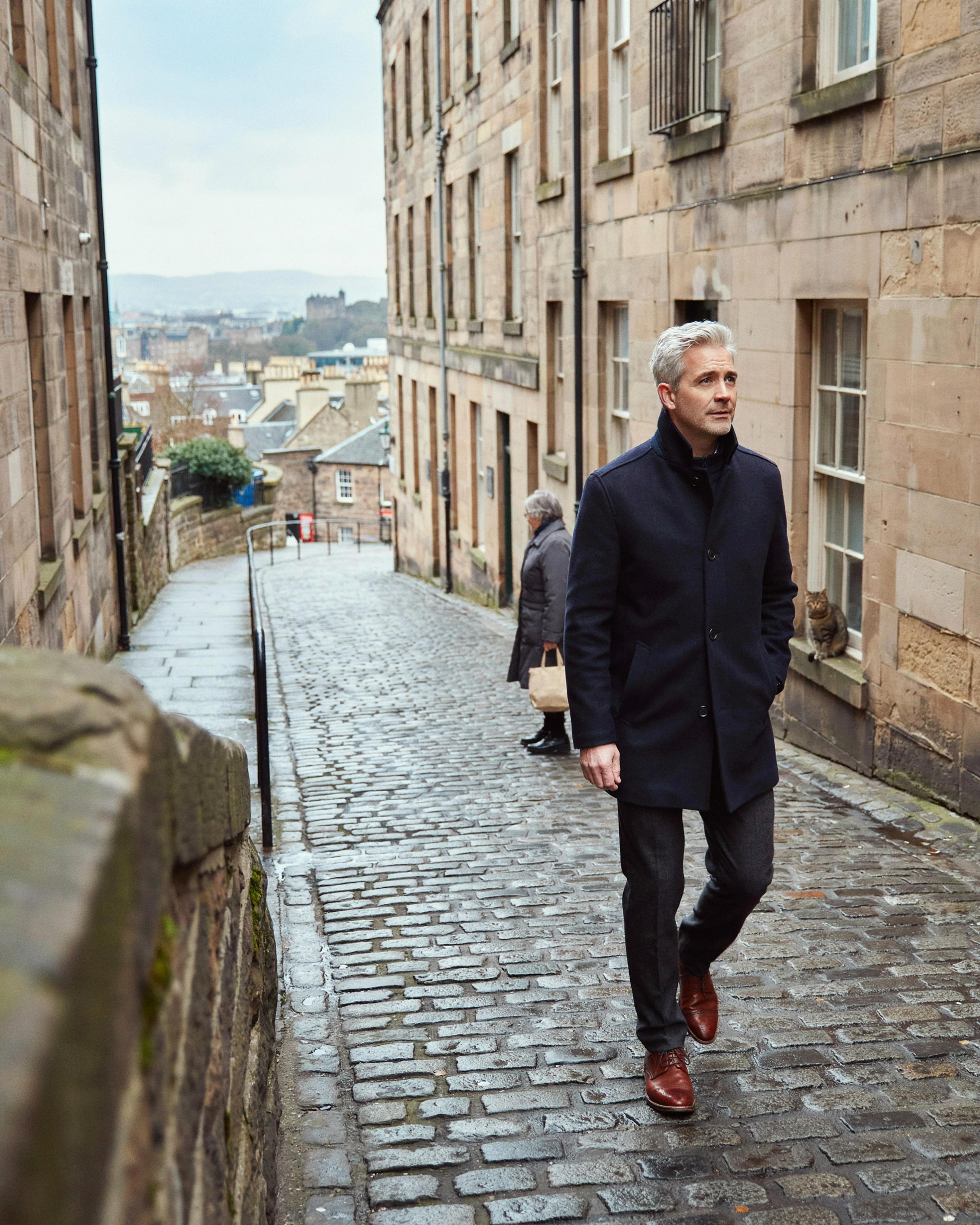 Man walking up a stone close off the Royal Mile in Edinburgh on a winter day