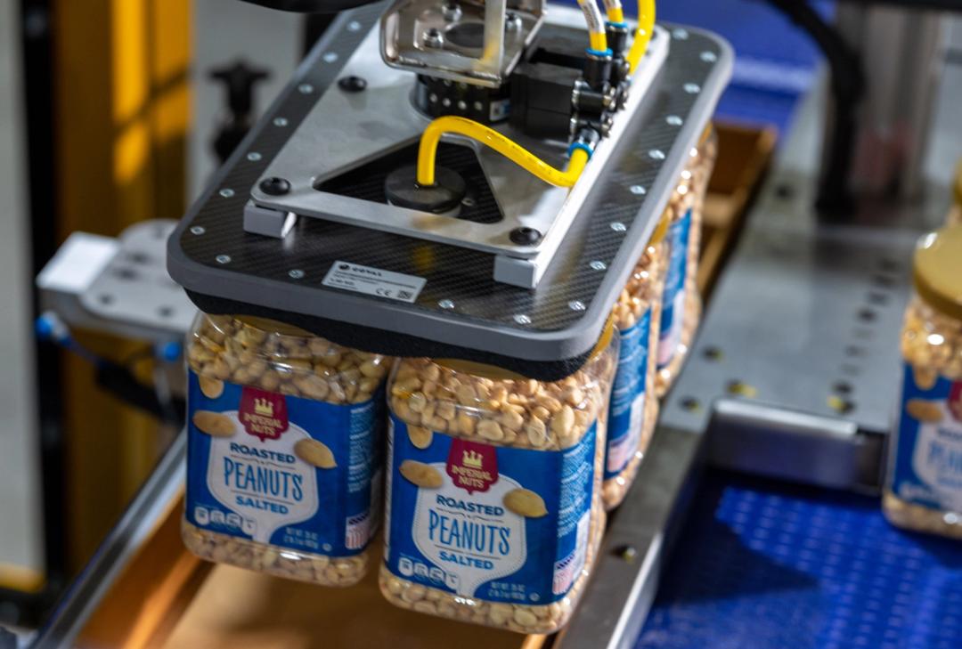 Robotic vacuum gripper lifting jars of peanuts during automated end-of-line case packing