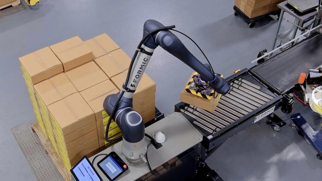 Formic cobot lifting a case onto a conveyor during automated palletizing