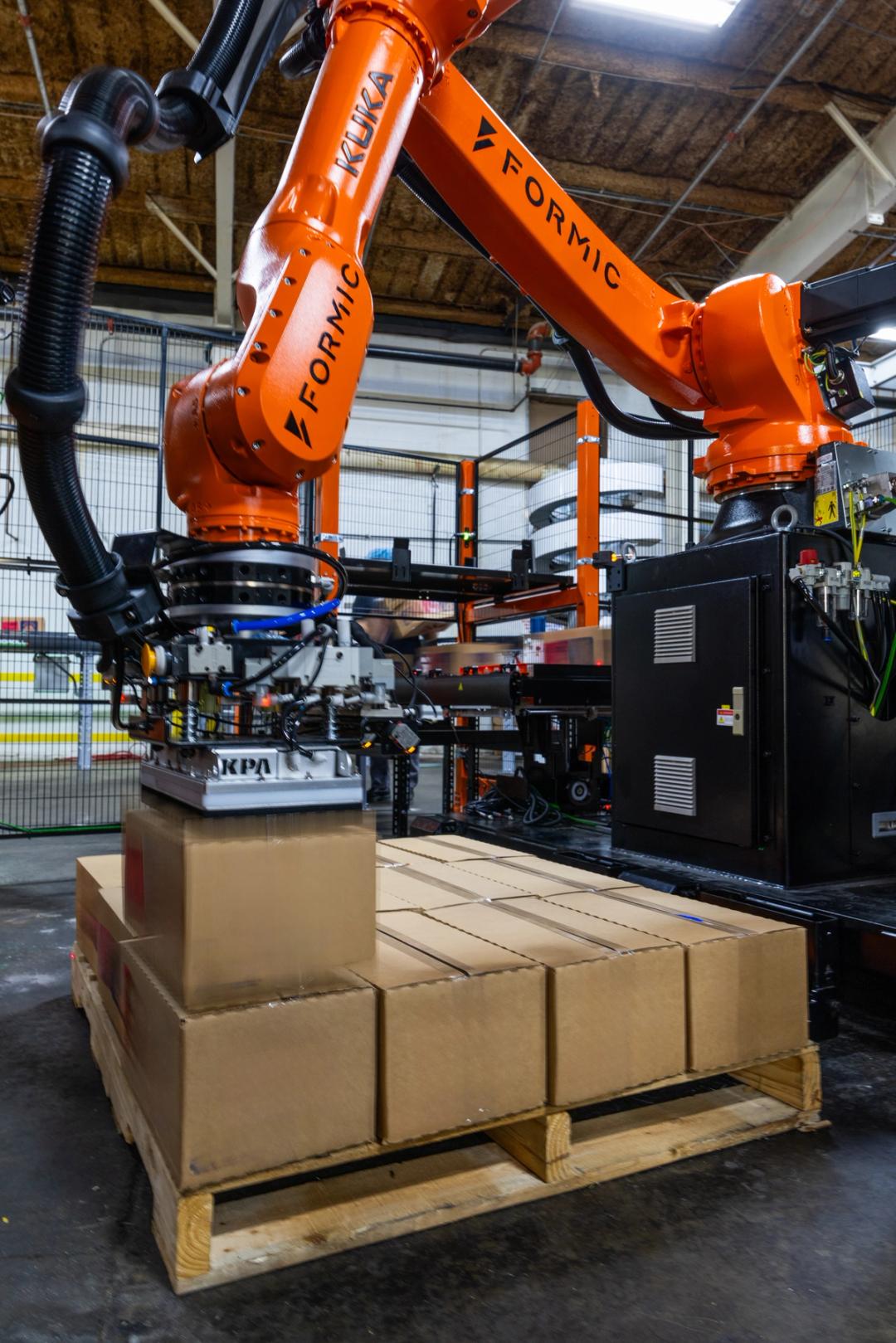 Robot stacking 28-pound water cases onto a pallet at a CPG facility