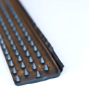 photo of black dimple board waterproofing membrane top cap dimple grip molding - it is flanged on one length and has cone shaped grid pattern to fit in dimple board