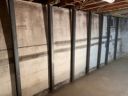 Six Gorilla Wall Braces installed in a row along a bowing basement foundation wall