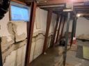 Gorilla Wall Braces installed against a foundation wall in a finished, lived-in basement