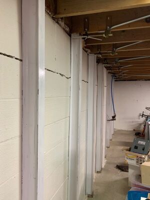 After photo of a white basement wall braced by Gorilla Wall Braces with the bowing wall straightened