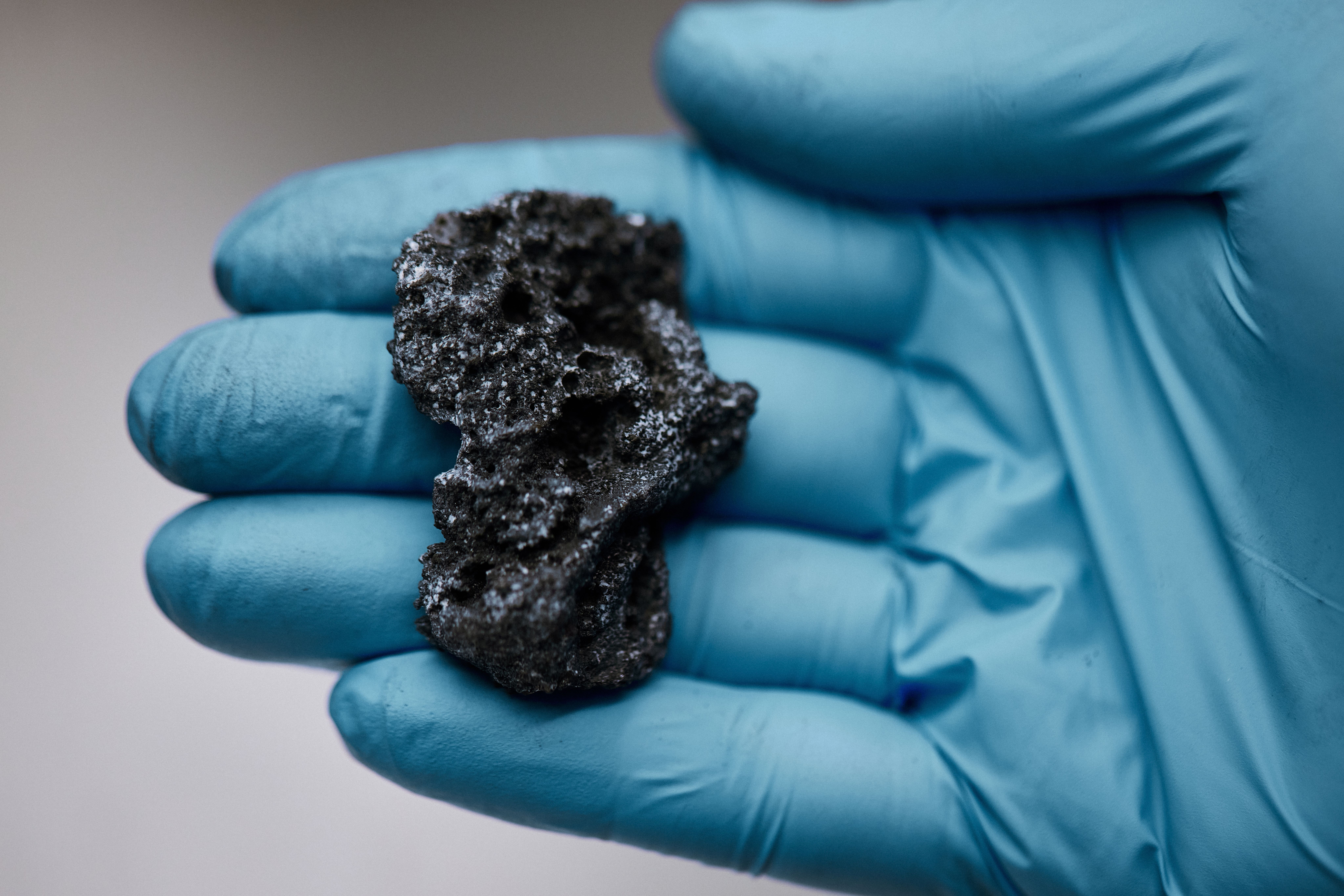 Lab worker holding lump of solid carbon