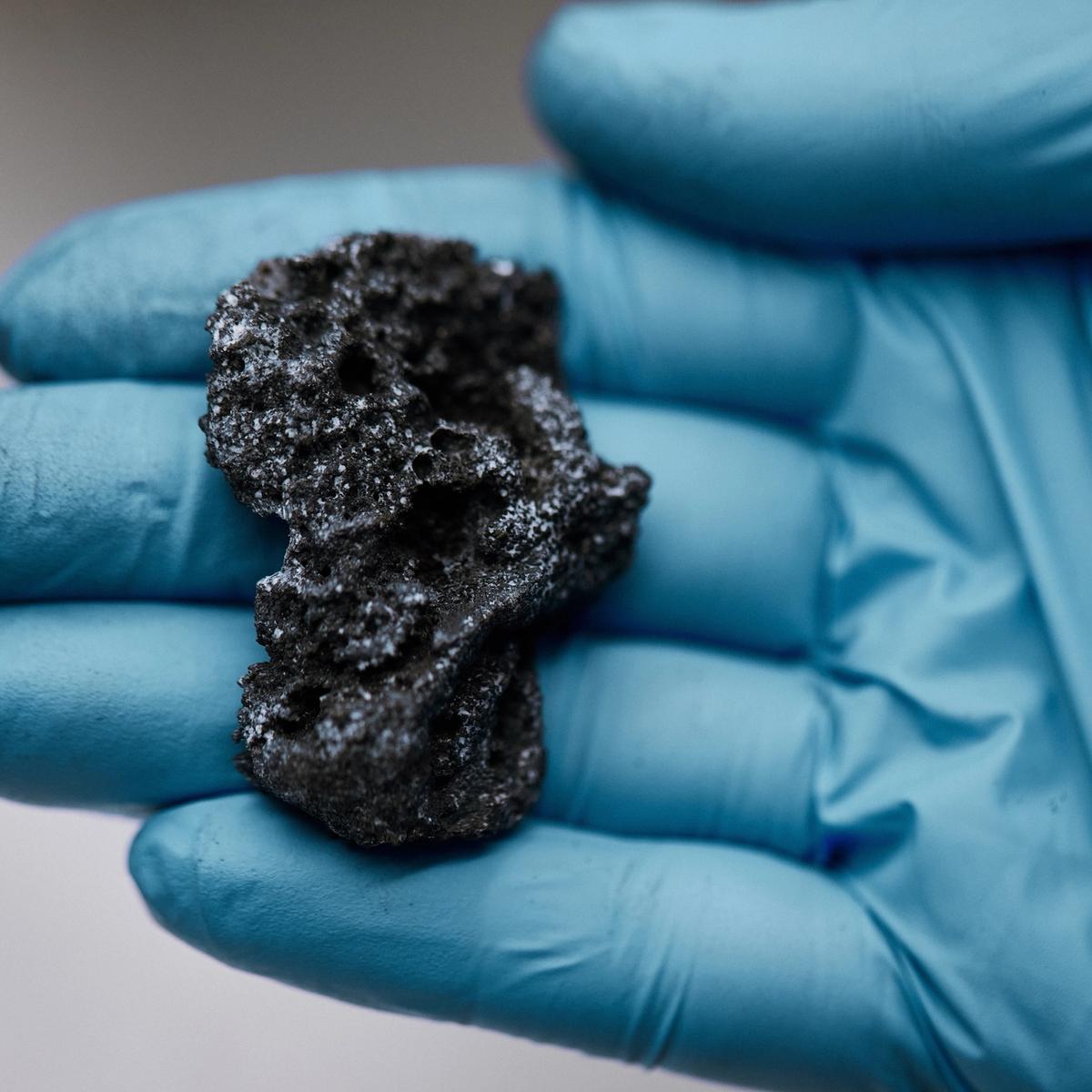 Lab worker holding lump of solid carbon