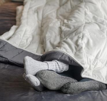 Cuddling under the cooling weighted blanket in light grey