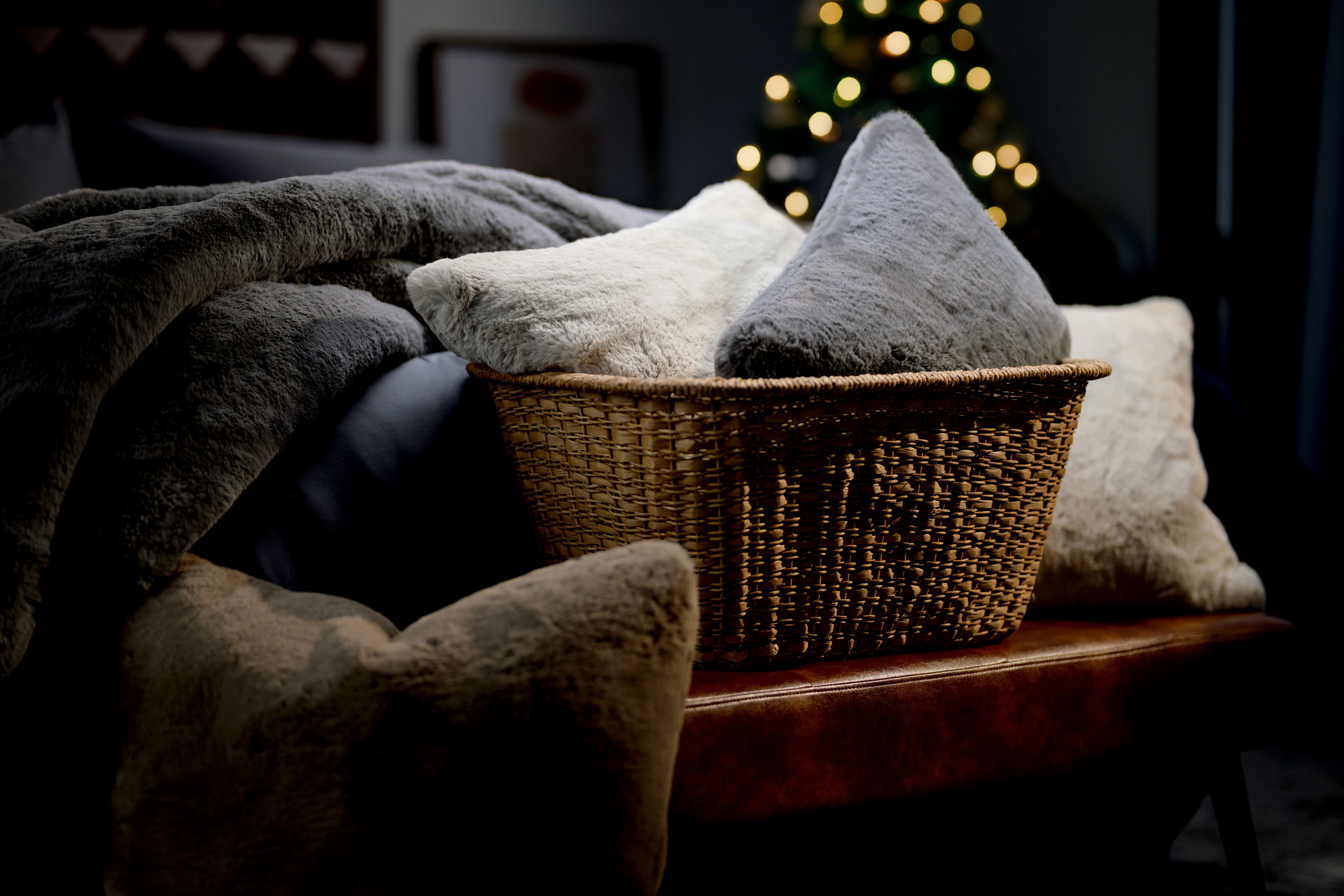 Basket full of luxuriously soft faux fur pillows & blankets