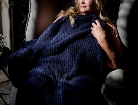 Cuddling under a cozy throw blanket in the color midnight