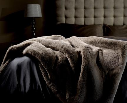 Faux Fur Blanket in truffle on bed